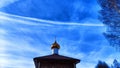 The dome of the Orthodox church with a cross, bare tree branches and blue sky with white clouds on a background in a Royalty Free Stock Photo
