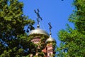 Dome of the Orthodox Church with crosses, view through the branches of trees against the blue sky Royalty Free Stock Photo