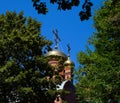 Dome of the Orthodox Church with crosses, view through the branches of trees against the blue sky Royalty Free Stock Photo