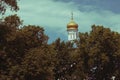 The dome of the Orthodox church over the trees. Golden dome against the blue sky. Autumn landscape Royalty Free Stock Photo