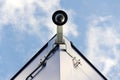 Dome security camera on wall, blue sky background copy space