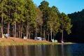 Dome tents near lake and pine trees in camping site at Pang Ung