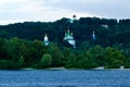 The domes Saint George`s Cathedral and ancient Michael`s Cathedral of Vydubychi Monastery over the old trees Royalty Free Stock Photo