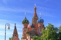Domes of St. Basil`s Cathedral in Moscow against green trees and blue sky on a sunny summer morning Royalty Free Stock Photo