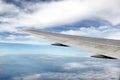 Domestic Airline Wing In Flight Over Water, With Clouds Royalty Free Stock Photo