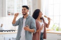 Domestic Band. Joyful Middle Eastern Spouses Fooling In Kitchen Together Royalty Free Stock Photo