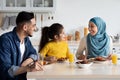 Domestic Breakfast. Happy Middle Eastern Family Of Three Eating Together In Kitchen Royalty Free Stock Photo