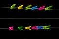 Colorful plastic clothespins in a row on a clothes lines on a black background. Royalty Free Stock Photo