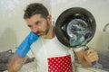 Domestic chores stress - young attractive overworked and stressed home cook man in red apron hating dishwashing feeling upset and Royalty Free Stock Photo