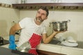 Domestic chores stress - young attractive overworked and stressed home cook man in red apron hating dishwashing feeling upset and Royalty Free Stock Photo