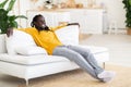 Domestic Comfort. Happy Young Black Guy Relaxing On Comfortable Couch At Home, Royalty Free Stock Photo