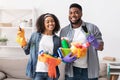 Domestic Duties. Happy Black Couple Posing With Cleaning Supplies In Hands