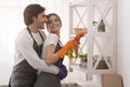 Domestic Duties. Young couple embracing while cleaning home together Royalty Free Stock Photo