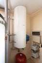 A domestic household boiler room with a new modern solid fuel boiler , heating electric warm water system and pipes.