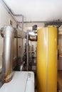 A domestic household boiler room with a new modern solid fuel boiler , heating electric warm water system and pipes.