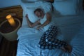 Domestic lifestyle high angle portrait of young attractive and relaxed man sleeping alone on bed at home lying tranquil at night