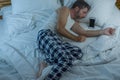 Domestic lifestyle high angle portrait of young attractive and tired man sleeping on bed holding mobile phone in internet and Royalty Free Stock Photo