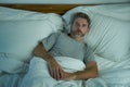 Domestic lifestyle high angle portrait of young handsome man awake at night with blue eyes wide open unable to sleep suffering Royalty Free Stock Photo