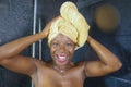 Lifestyle portrait of young beautiful black afro American woman having a shower with her head wrapped in a towel smiling cheerful Royalty Free Stock Photo