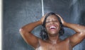 Domestic lifestyle portrait of young happy and beautiful black African American woman smiling happy taking a shower at home Royalty Free Stock Photo