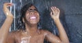 Domestic lifestyle portrait of young happy and beautiful black African American woman smiling happy taking a shower at home Royalty Free Stock Photo