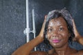 Domestic lifestyle portrait of young happy and beautiful black African American woman smiling happy taking a shower at home Royalty Free Stock Photo