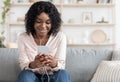 Domestic Pastime. Relaxed African American Woman Listening Music With Smartphone And Earphones