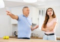 Domestic quarrel between elderly father and adult daughter in kitchen