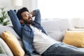 Domestic Rest. Young Handsome Indian Guy Leaning Back On Couch At Home