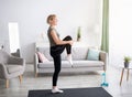 Domestic sports concept. Athletic mature woman in sportswear doing fitness exercises on yoga mat indoors, copy space Royalty Free Stock Photo