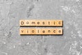 Domestic violence word written on wood block. Domestic violence text on cement table for your desing, Top view concept Royalty Free Stock Photo
