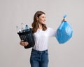 Domestic Waste Sorting. Lady Holding Garbage Bag And Bucket With Plastic Bottles Royalty Free Stock Photo