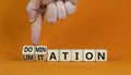 Domination or limitation symbol. Businessman turns cubes, changes the word domination to limitation. Beautiful orange table,