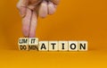 Domination or limitation symbol. Businessman turns cubes, changes the word domination to limitation. Beautiful orange table,