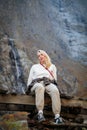 Moment of solitude, girl on the bridge by the waterfall in the mountains