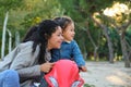 Dominican mother and son looking at a side on a balance bike in a park. Royalty Free Stock Photo