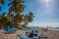 Dominican Republic. 20 NOVEMBER 2021. Caribbean beach with a lot of palms and white sand, sunbeds. Sunny warm day at the sea under Royalty Free Stock Photo