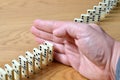 Domino effect, chain reaction is stopped by a human hand Royalty Free Stock Photo
