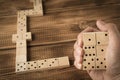 Domino. A human hand with a Domino. A game of dominoes on a wooden table Royalty Free Stock Photo
