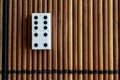 Domino piece on the bamboo brown wooden table background. Domino set - four - 5 dots.