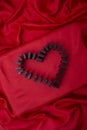 domino tiles forming a heart shape on red satin fabric Royalty Free Stock Photo