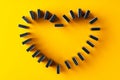 Domino tiles set in a heart shape on yellow background top view Royalty Free Stock Photo