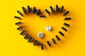 Domino tiles set in a heart shape on yellow background top view Royalty Free Stock Photo