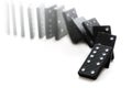 Dominoeffect with falling black dominos on a white background Royalty Free Stock Photo