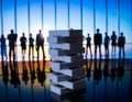 Dominoes on a background of silhouettes of business people