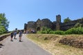 Domme, France 15 july 2019: Tourists walking toward and away form the Tower Gate or Porte des Tours medieval entrance to the town Royalty Free Stock Photo