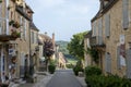 Domme, France - picturesque street with stone houses and blossoming flowers in the historic village of Domme in the Dordogne