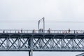 Don Luis I steel bridge in Porto with rain clouds in the background with people walking, cycling and taking photos of the Douro Royalty Free Stock Photo