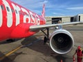Jet engine generate thrust under the wing of Thai Airasia, Airbus A320 airplane parked on the parking lot with ground staff.