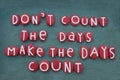 Don`t count the days, make the days count, creative quote composed with red colored stone letters